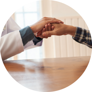 Healthcare professional shakes the patient's hand and talks to the patient to comfort him.
